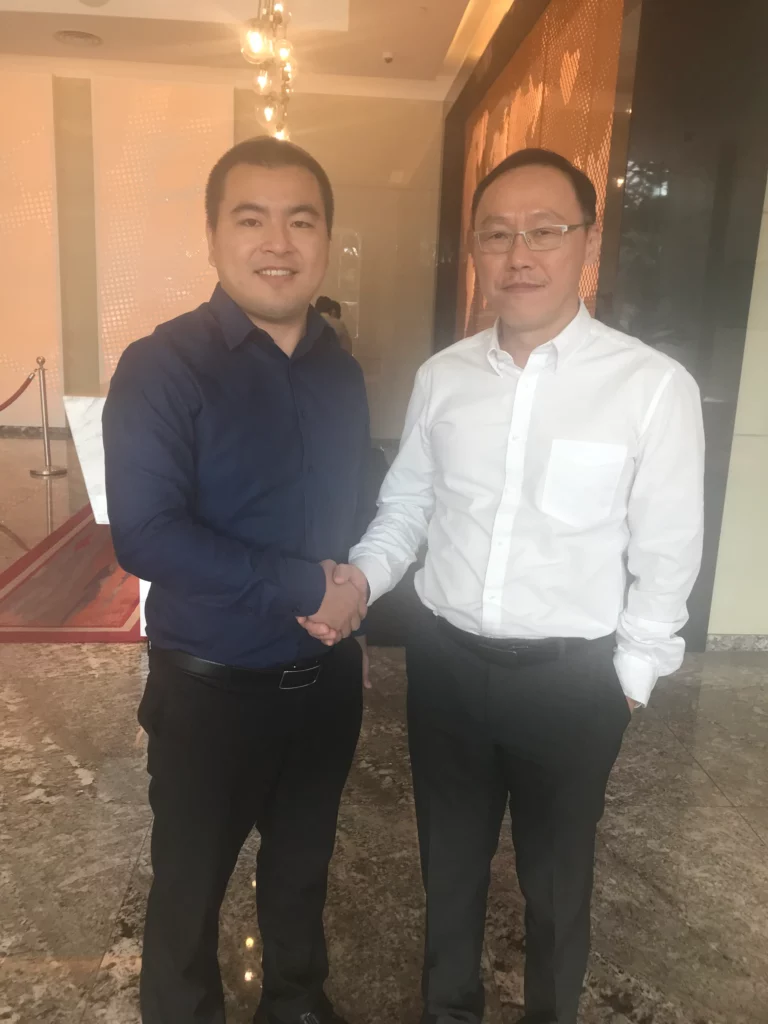 Akicare representative shaking hands with a business contact in a hotel lobby