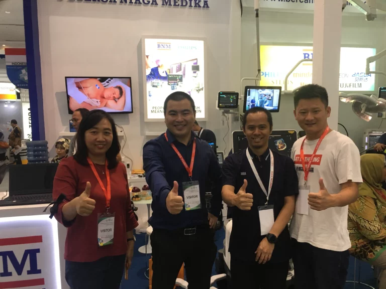 Akicare representative with business contacts at a medical equipment exhibition stand