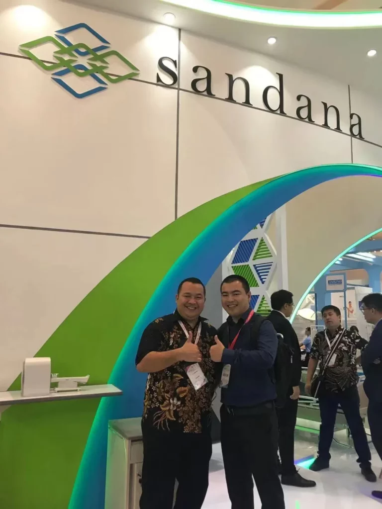 Akicare representative with business contacts at an exhibition stand