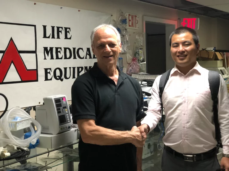 Akicare representative shaking hands with a business contact at a medical equipment office