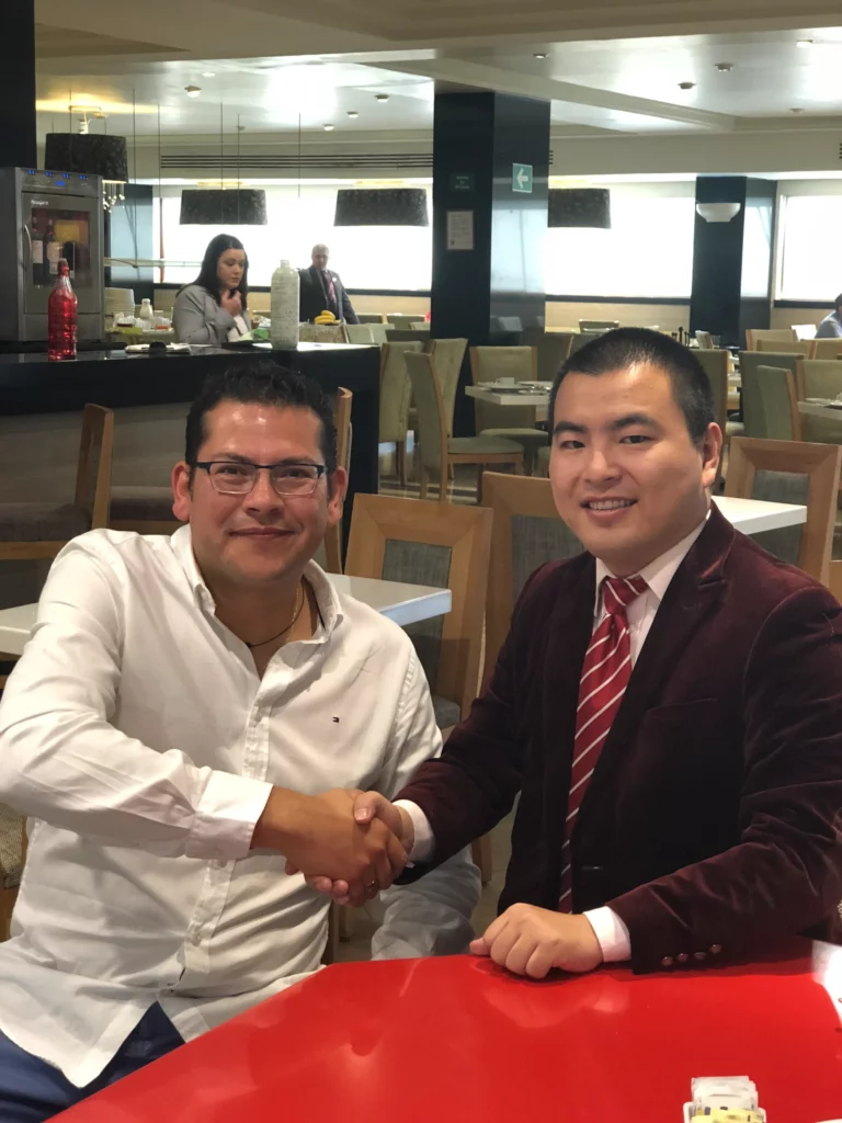 Akicare representative shaking hands with a business contact at a restaurant table