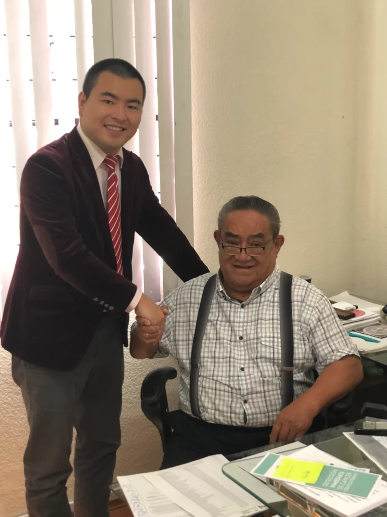 Akicare representative shaking hands with a business contact at an office desk