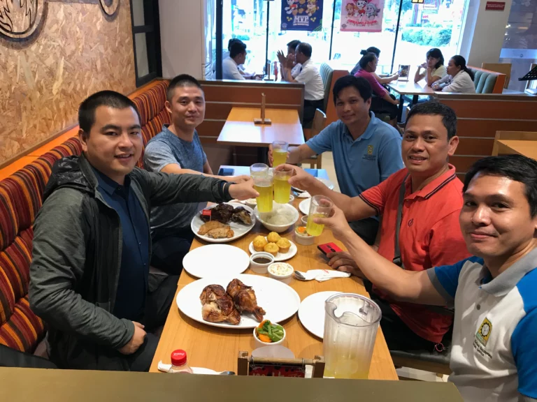 Akicare representative with business contacts at a restaurant table